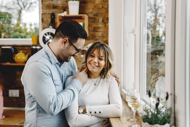 istock Happy couple talking while standing by the window in the kitchen. 1208420804