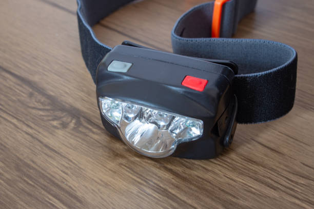 istock Black led headlamp turned off on a wooden table showing the elastic strap 1208421206