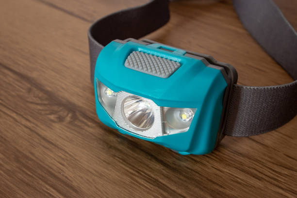 istock Teal led headlamp turned off on a wooden table showing the elastic strap 1208421238
