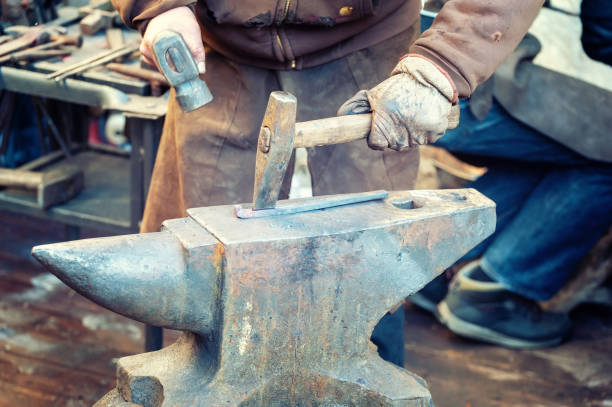 istock Blacksmith working metal with hammer on the anvil 1208423118