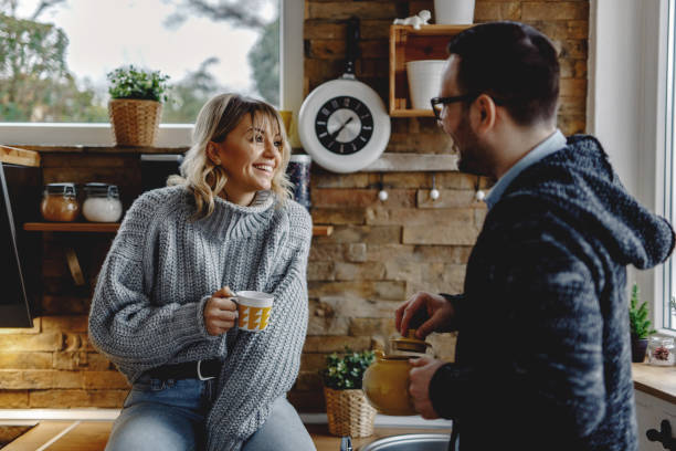 istock Happy couple talking to each other in the kitchen. 1208423740