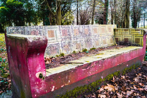 istock Old worn stone bench to sit among trees on a sunny day 1208424061