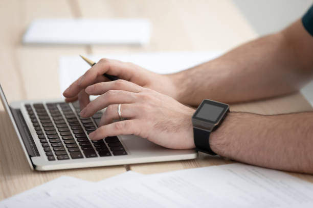 istock Close up young businessman typing message on laptop in office. 1208424210