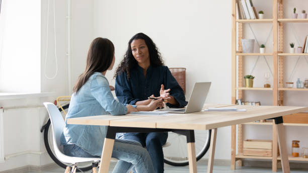 istock Young mixed race coworkers discussing working issues together at workplace. 1208424263