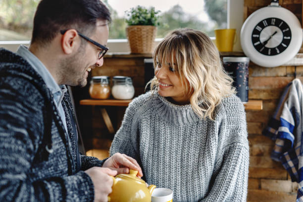 istock Happy couple talking while enjoying in cup of tea in the kitchen. 1208424325
