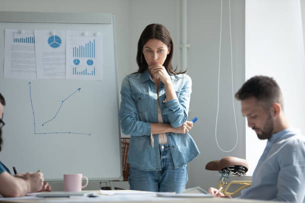 istock Stressed young woman standing near flipchart, feeling nervous. 1208424350