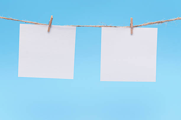 istock Blank Paper, hanging on rope by pin against blue Background, concept, office 1208427933