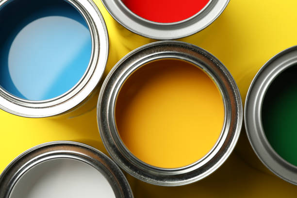 istock Paint cans on yellow background, top view and closeup 1208435775