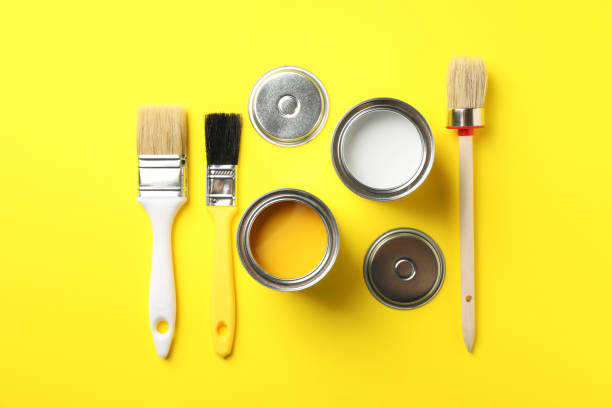istock Cans of paints and brushes on yellow background, top view 1208436249