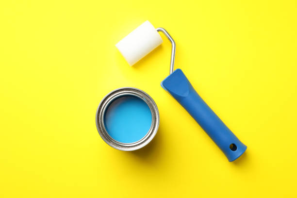 istock Paint can and roller on yellow background, top view 1208436309