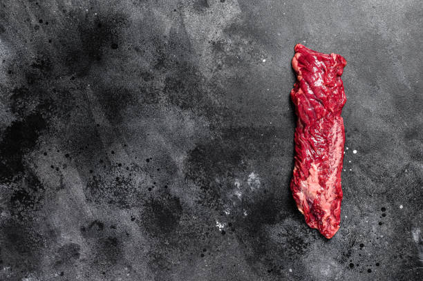Raw skirt, machete steak. Black background. Top view. Copy space