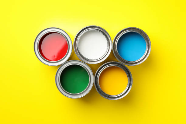 istock Cans of different paints on yellow background, top view 1208436966
