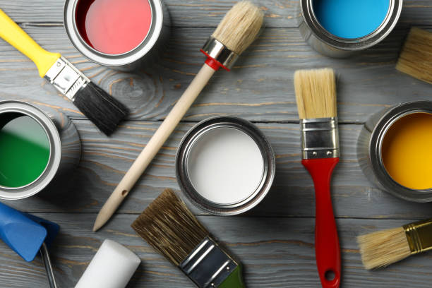 istock Different paints, brushes and roller on wooden background, top view 1208437489