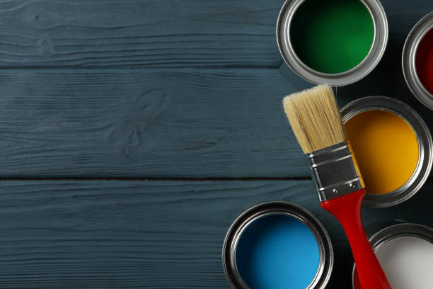 istock Paint cans and brush on wooden background, top view 1208437521