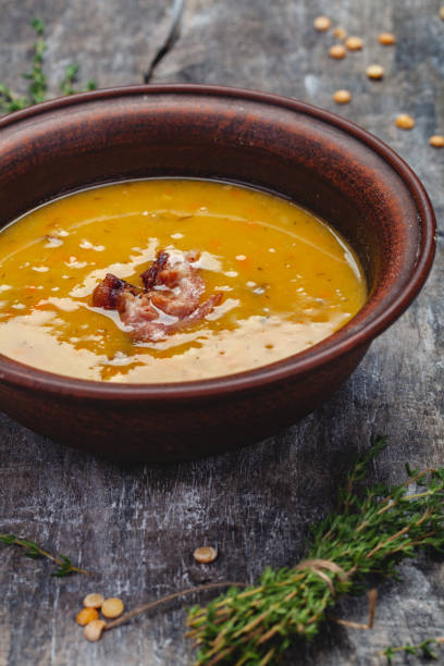 istock Pumpkin pea soup with bacon on wooden background. Close up 1208437529