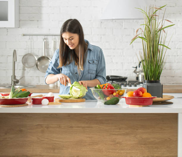 istock A young woman is preparing a salad in the kitchen . 1208438258