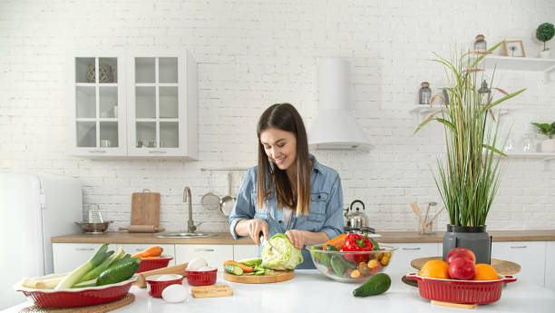 istock A young woman is preparing a salad in the kitchen . 1208438264