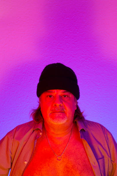 istock Studio portrait of man posing under colorful lights 1208439223