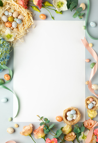 Happy Easter concept with easter eggs in nest and spring flowers. Easter background with copy space. Flat lay.