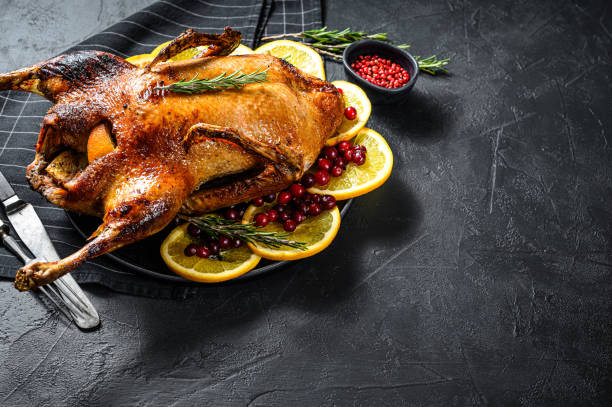 istock Baked duck stuffed with oranges and rosmarina. Festive table. Black background. Top view. Space for text 1208439402