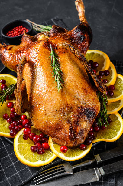 istock Baked goose stuffed with oranges and rosmarina. Festive table. Black background. Top view. 1208439507