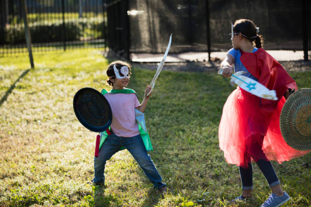 istock Hispanic children in superhero costumes, rivalry 1208439723