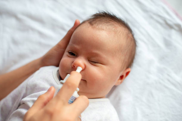 istock Woman using nasal spray for baby 1208439730