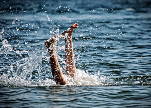 istock Legs Of Swimmer Diving Into Water With Splashing 1208439944