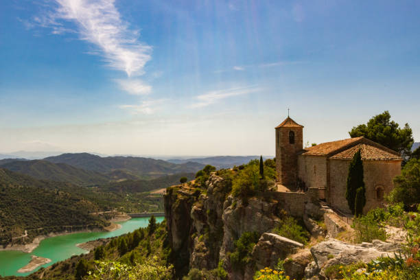 istock church in a cliff next to a green river. 1208440750