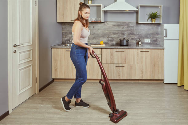 istock One young woman uses a wireless vacuum cleaner. 1208441228