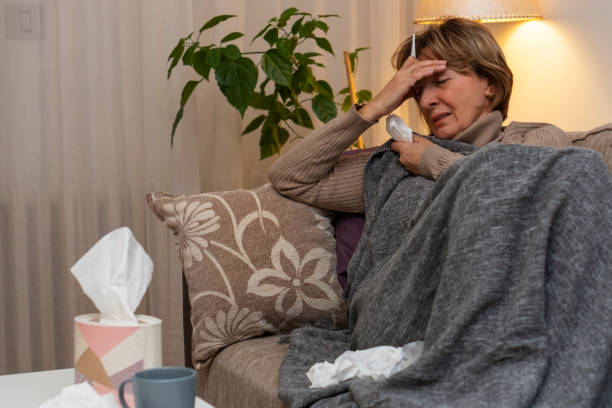istock Senior woman feeling sick at home 1208443101