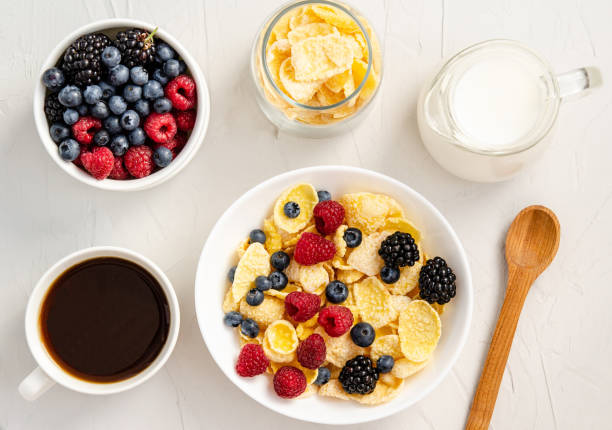 istock Ingredients for a healthy breakfast - cornflakes, berries, milk and coffee on a white background 1208444166