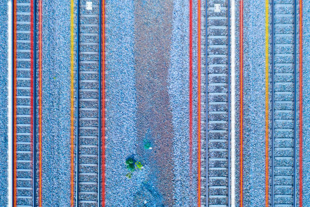 Red and yellow train tail lights over railway track seen from above