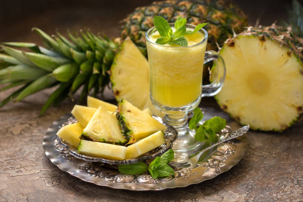 Ripe pineapples (Ananas comosus) and a glass of fresh juice on a vintage dish Ripe pineapples (Ananas comosus) and a glass of fresh juice on a vintage dish silver platter stock pictures, royalty-free photos & images
