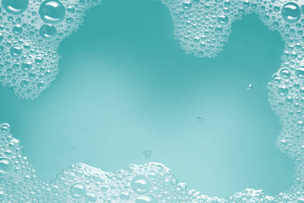 Soap suds background Close-up of soap suds with water on a turquoise blue background. Space for copy. shampoo photos stock pictures, royalty-free photos & images