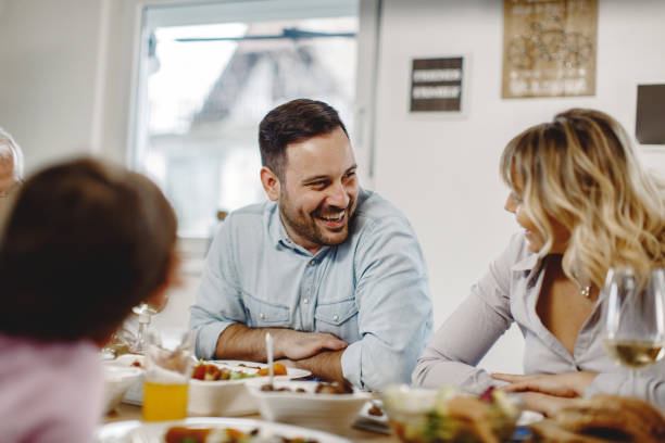 istock Happy couple talking to each other at dining table. 1208452825