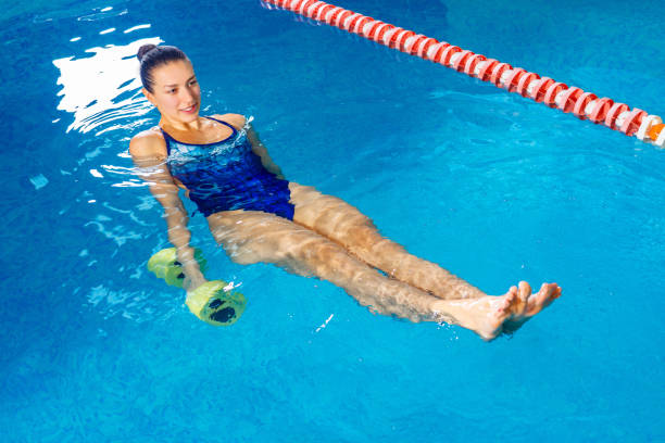 istock Young woman doing water aerobics in indoor pool, sporting concept 1208452949