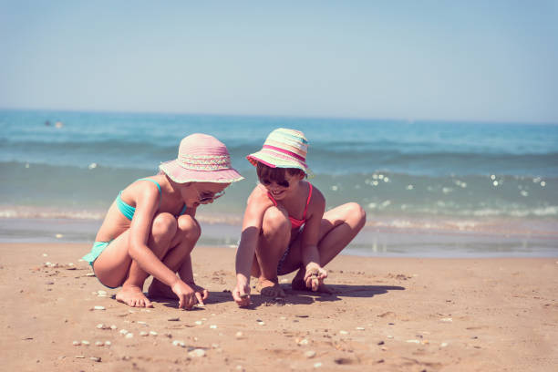 istock Schoolgirl collecting sea shells on the beach 1208453191