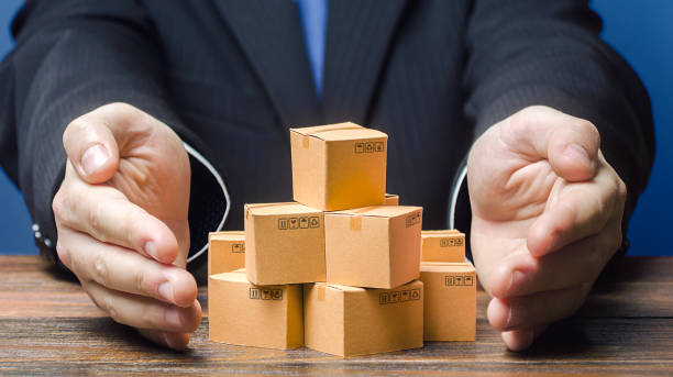 istock Businessman covers boxes goods. Business management. Commodity circulation import export. Support manufacturer, attracting investments, promoting products to new markets. Marketing sales, distribution 1208453220