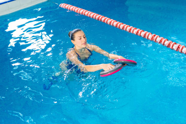 Young woman doing water aerobics in indoor pool, sporting concept