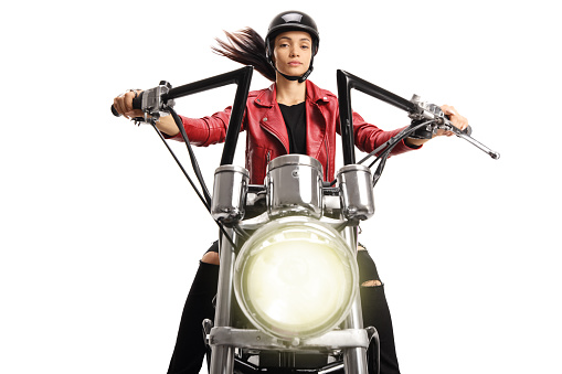 Portrait of a female biker riding a custom motorbike isolated on white background
