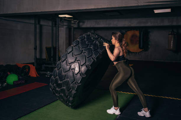 istock A young athlete who trains with a huge machine wheel. A young athlete who practices gym 1208457088