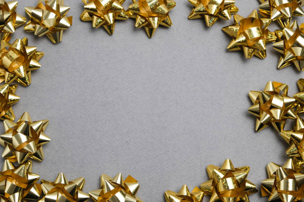 istock Golden bows on gray table top view. Flat lay composition for wedding, Christmas or birthday 1208457108