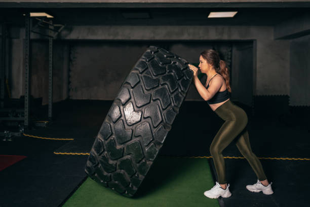 istock A young athlete who trains with a huge machine wheel. A young athlete who practices gym 1208457168
