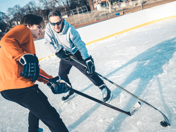 istock Father and son playing hockey outdoors 1208457347