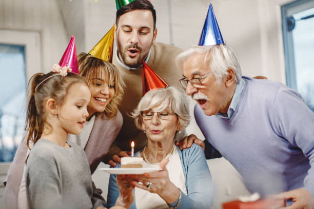 istock Happy multi-generation family blowing Birthday candle on a cake. 1208457428
