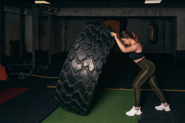 istock A young athlete who trains with a huge machine wheel. A young athlete who practices gym 1208457551