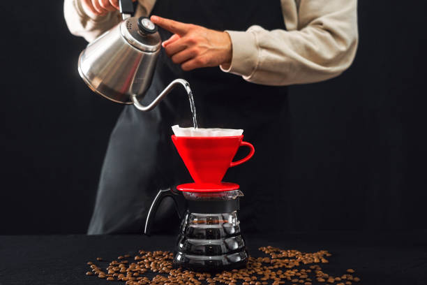 istock A barista brews coffee by an alternative method in pour over, coffee filter on a dark background. 1208458634