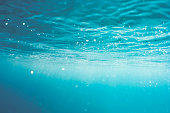 Underwater abstract wave, sunlight through water, sparkling reflections and sun light beams.