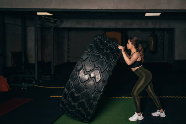 istock A young athlete who trains with a huge machine wheel. A young athlete who practices gym 1208462546